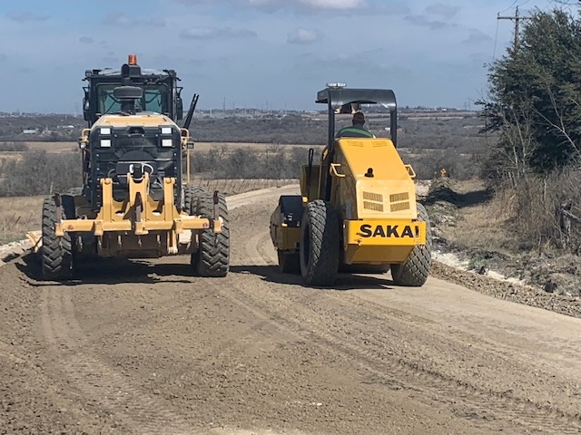 heavy equipment preparing a road for paving