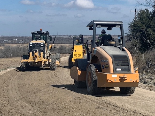 heavy equipment preparing a road for paving